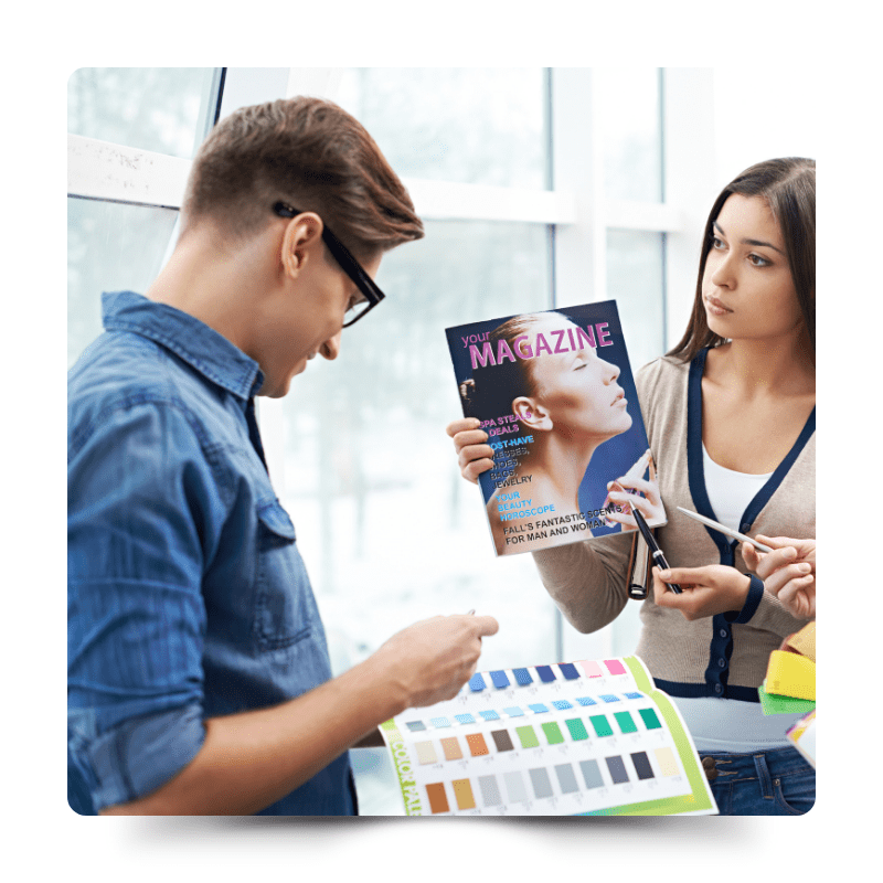 這張圖片展示了兩位專業設計師在光線充足的工作室中討論雜誌設計。兩人正在檢視色卡和雜誌封面，專注於協同工作，顯示出NAS在自由職業者和設計專業人員中的應用，支持高效的文件共享和協作。