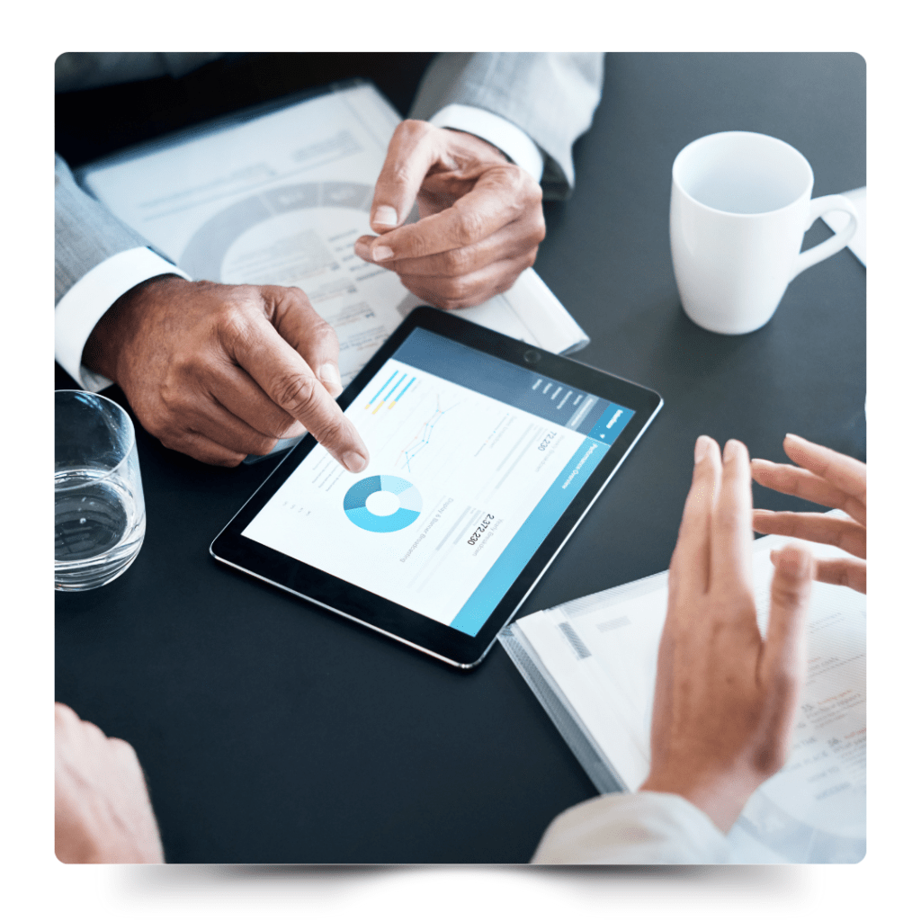 幾位商務人士圍坐在會議桌旁，使用平板電腦展示和討論數據圖表，展現出使用NAS交流數據，協作和高效的工作場景。